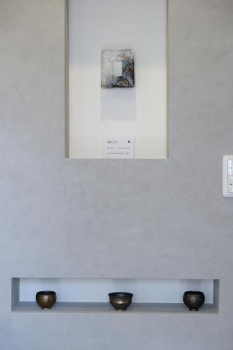 a display case with two black bowls on a wall at Jasmin T18 高松港近く 静かで美しい別荘 in Takamatsu