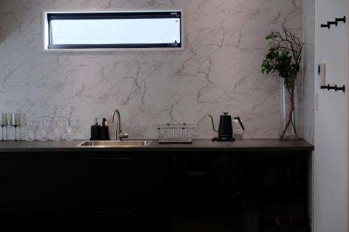 a kitchen counter with a sink and a window at Jasmin T18 高松港近く 静かで美しい別荘 in Takamatsu
