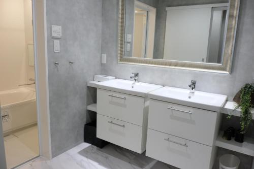 a bathroom with two sinks and a mirror at Jasmin T18 高松港近く 静かで美しい別荘 in Takamatsu