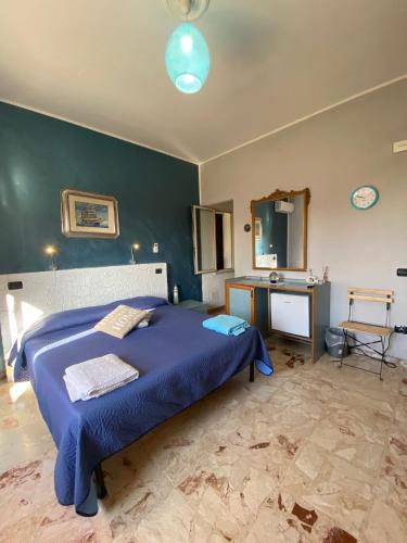ein Schlafzimmer mit einem blauen Bett und einem Waschbecken in der Unterkunft Orion Accomodation in Tropea