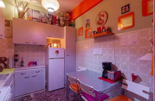 a kitchen with a white refrigerator and a table at Casa Di Fiori Pireas in Piraeus