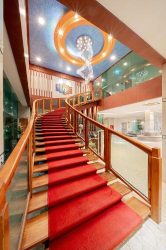 a staircase with a red carpet and a chandelier at Royal Prince Resort Pattaya in Pattaya South