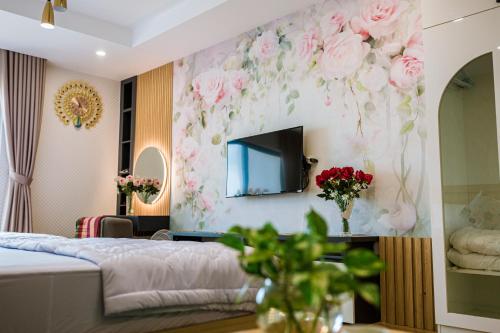 a bedroom with pink flowers on the wall at TMS Luxury Codotel Quy Nhơn - Ban Công Trực Diện Biển, Có Bếp in Quy Nhon