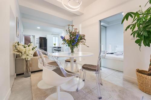 une salle à manger avec une table et des chaises blanches dans l'établissement La Perle du Mourillon-WIFI-Spacieux Haut de gamme, à Toulon