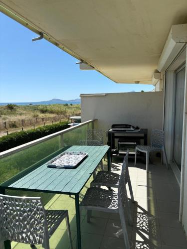 d'une table et de chaises sur un balcon avec barbecue. dans l'établissement St Cyprien T3 lumineux en bord de plage Piscine, à Saint Cyprien Plage