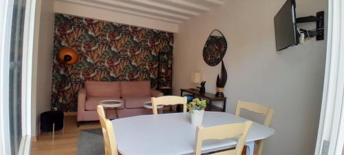un salon avec une table et un canapé dans l'établissement Appartement en plein cœur de Honfleur, à Honfleur