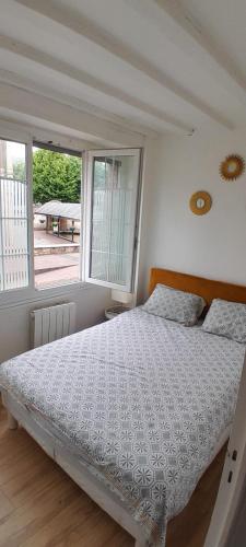 une chambre avec un lit et une grande fenêtre dans l'établissement Appartement en plein cœur de Honfleur, à Honfleur