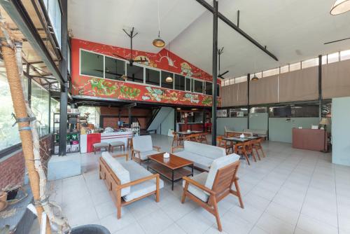 a restaurant with tables and chairs in a room at Sans Stay Skyland Pasteur Bandung in Bandung