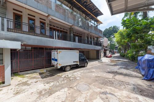 a small truck parked in front of a building at Sans Stay Skyland Pasteur Bandung in Bandung