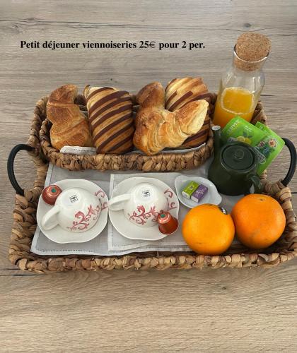 a tray of breakfast food with croissants and oranges at Cocon cosy appart romantique, jacuzzi piscine in Puget