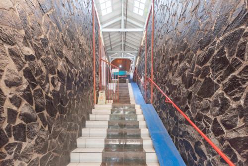 a stairway in a building with a stone wall at Sans Stay Skyland Pasteur Bandung in Bandung
