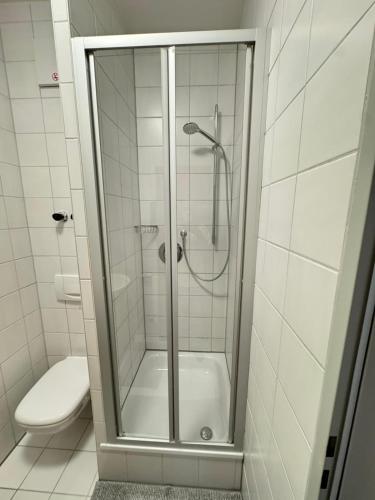 a shower with a glass door in a bathroom at Ferienzimmer am Marktplatz in Bad Saulgau