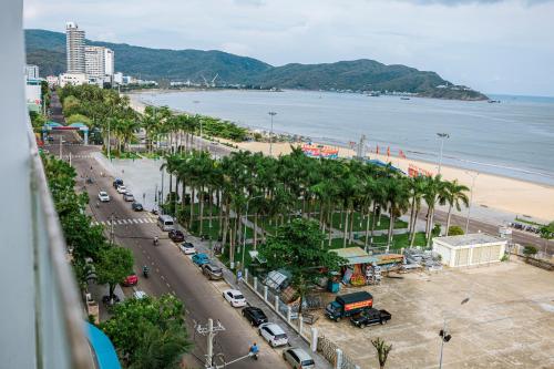 a view of a beach with palm trees and a street at TMS Quy Nhơn - Có Ban Công Và Tầm Nhìn Biển, Phù Hợp Với Gia Đình Có Bếp in Quy Nhon