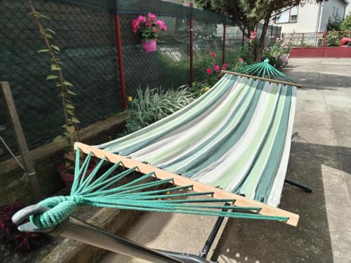 a hammock laying on the ground in a garden at Family House in Golubac