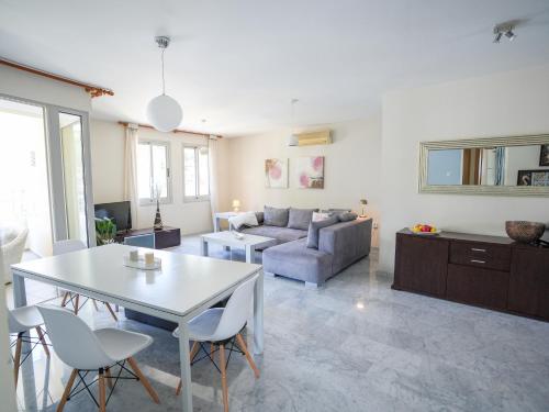 a living room with a table and a couch at Mediterranean Escape - Coastal 2-Bedroom Apartment Limassol in Limassol