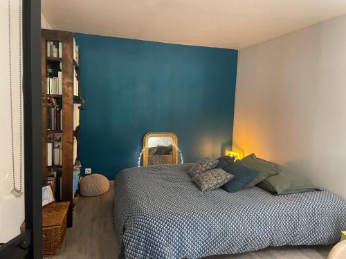 une chambre avec un mur bleu et un lit dans l'établissement Joli rez de villa proche d'Aix-en-Provence, à Peyrolles-en-Provence