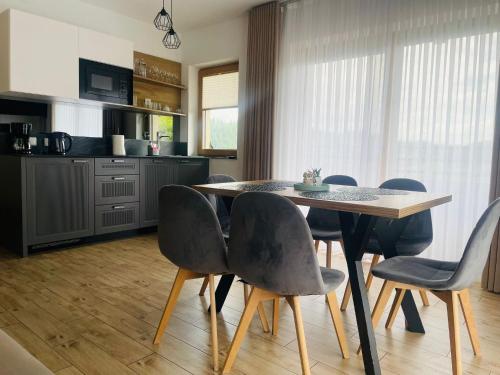 a kitchen with a dining room table and chairs at Domki Sówka in Dursztyn