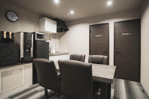 a kitchen with a table and chairs in a room at Laon Inn Miyakojima in Miyako-jima