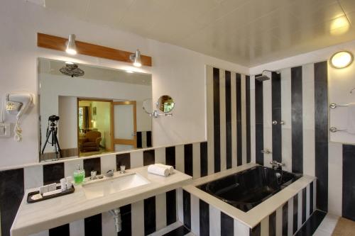 a bathroom with a sink and a mirror at Hotel Inn Season - Art Deco Heritage Hotel in Jodhpur in Jodhpur