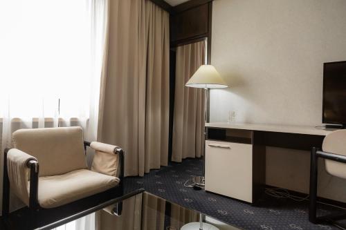 a hotel room with a chair and a television at Hotel Holiday in Sarajevo