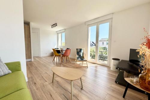 un salon avec un canapé vert et une table dans l'établissement T2 - Balcon - Au coeur des chênes, à Ploemeur