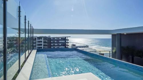 a swimming pool on top of a building with the ocean at Luxury Palm Beach Getaway in Gold Coast