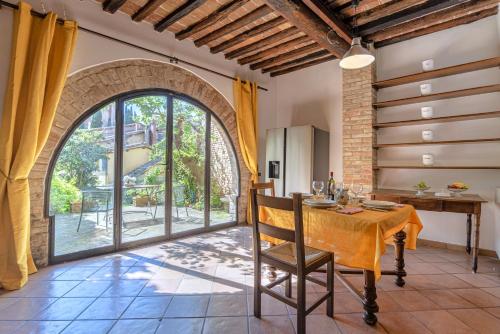 a dining room with a table and a large window at Il Nido dell'Oca - Loft Giardino in Siena