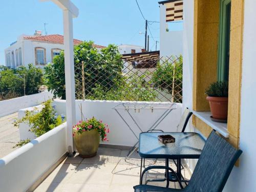 a patio with two chairs and a table on a balcony at Sophia's Apartments - Lipsi Thyme in Lipsoi