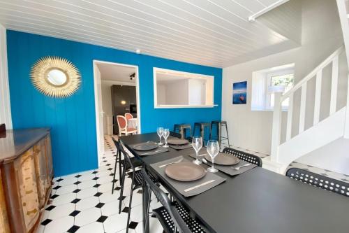 une salle à manger avec des murs bleus et une table et des chaises dans l'établissement Longère de charme cosy - Proche des plages, à Ploemeur