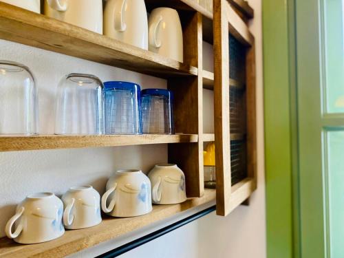 a row of blue and white cups on a shelf at Sophia's Apartments - Lipsi Thyme in Lipsoi