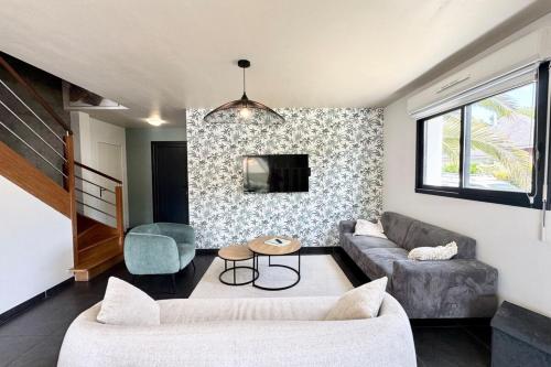 un salon avec un canapé et une table dans l'établissement Belle maison contemporaine aux portes de Lorient, à Kervignac