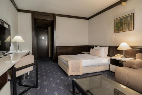 a hotel room with a bed and a couch at Hotel Holiday in Sarajevo