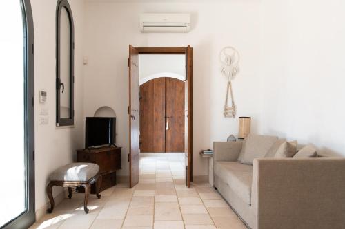 a living room with a couch and a tv at Cisternino Villa in Olive Groove in Cisternino