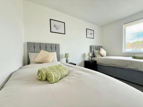 a bedroom with a large white bed with two pillows at Long Term Comfort - 2BR Haven in Cheshunt