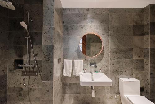 a bathroom with a sink and a shower at Shanyu Life Huangshan Design Hotel in Huangshan