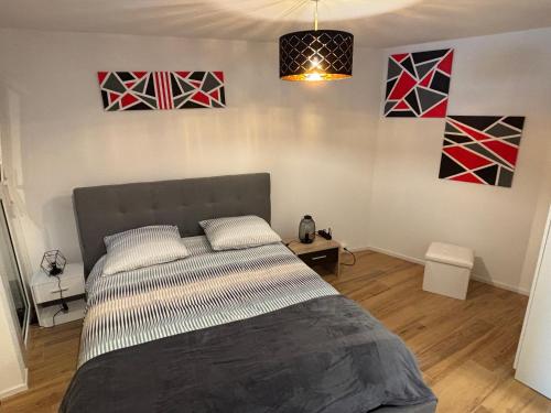 een bed in een kamer met schilderijen aan de muur bij Deux pas du lac & Centre de Montreux in Veytaux