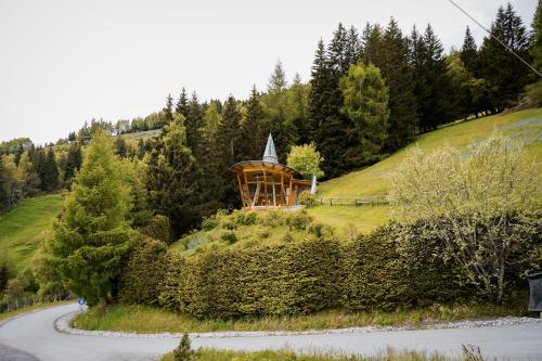 a small chapel on a hill with a road at Puitalm Apartments & SPA by Peak Stay in Arzl im Pitztal