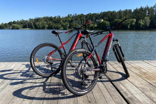a red bike parked on a dock next to the water at Na samotě u lesa in Vsetín