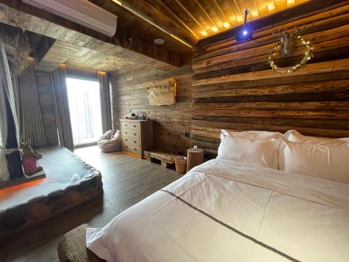 a bedroom with a bed and a wooden wall at 哲帆民宿百年风化老木屋 in Zengjia
