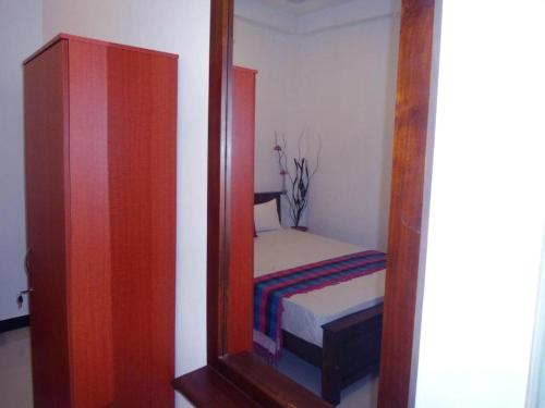 a mirror reflecting a small bedroom with a small bed at JK Villa in Wadduwa