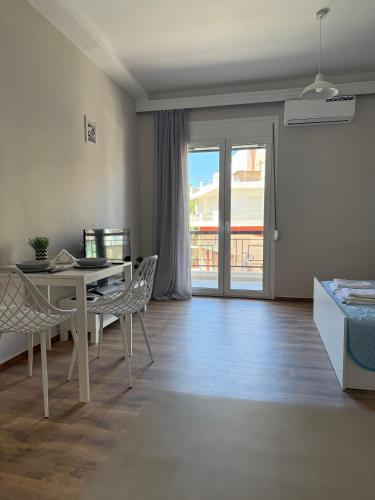 a living room with a table and chairs and a balcony at The Chalkida Nook Central Spot in Chalkida