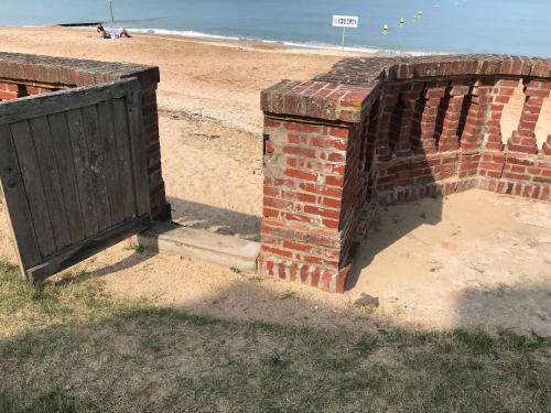 un mur de briques et une porte sur la plage dans l'établissement maison accès plage direct - 6 couchages - emplacement exceptionnel, à Houlgate
