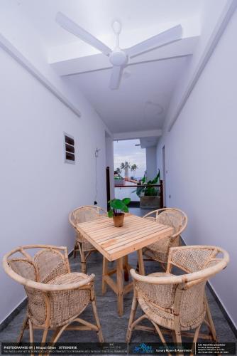 a dining room with a wooden table and chairs at BLUE WHALES HOTEL in Hikkaduwa