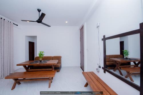 a living room with two tables and a couch at BLUE WHALES HOTEL in Hikkaduwa