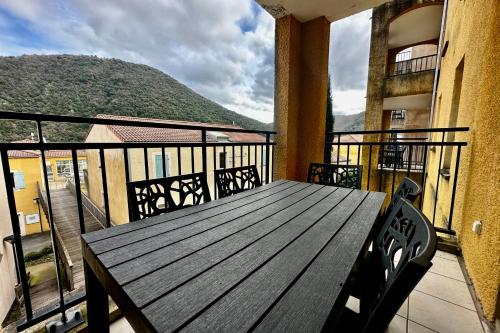 a wooden table on a balcony with a view of a mountain at Les Naïades I45 - 2 bedrooms for 5 people ! in Avène