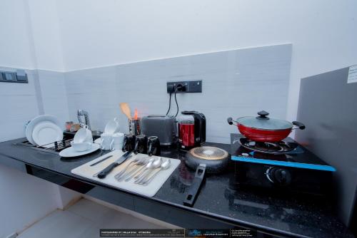 a kitchen counter with a red pot on a stove at BLUE WHALES HOTEL in Hikkaduwa