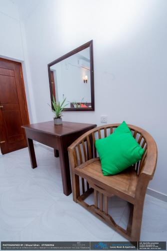 a room with a table and a bench with a green pillow at BLUE WHALES HOTEL in Hikkaduwa