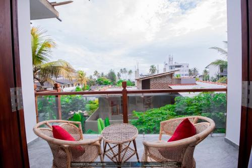 a balcony with chairs and a view of a city at BLUE WHALES HOTEL in Hikkaduwa