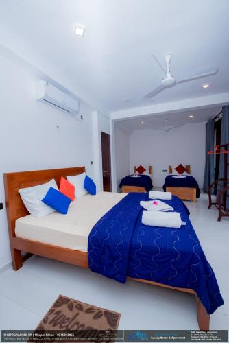 a bedroom with a large bed with a blue blanket at BLUE WHALES HOTEL in Hikkaduwa