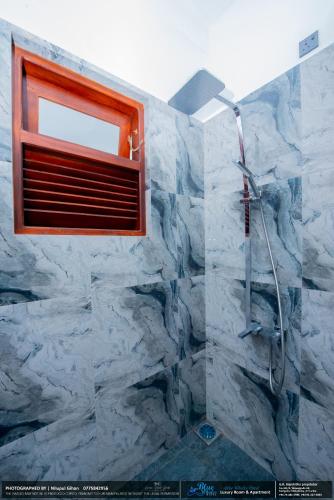 a bathroom with a stone shower with a window at BLUE WHALES HOTEL in Hikkaduwa